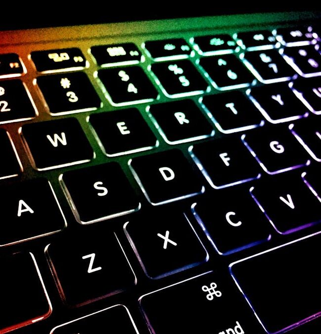 Close-up of a colorful backlit keyboard with glowing keys.